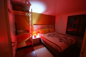 ein rotes Schlafzimmer mit einem Bett mit einer Lampe in der Unterkunft B&B Taccu Maccu in Ulassai