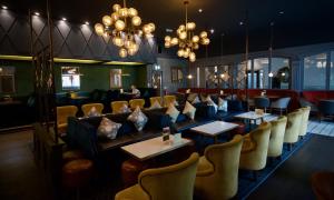 a restaurant with chairs and tables and chandeliers at Balmoral Hotel, Belfast in Belfast