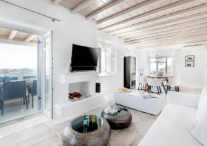 a living room with a couch and a tv at Diana Villa Mykonos in Agios Ioannis Mykonos