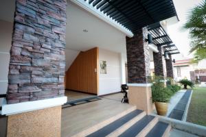 an external view of a house with a stone wall at Fortune Surin Hotel in Surin