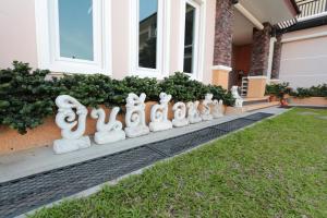 a row of white statues in front of a house at Fortune Surin Hotel in Surin +18 photos