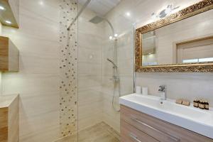 a bathroom with a shower and a sink and a mirror at Przy plaży in Gdańsk