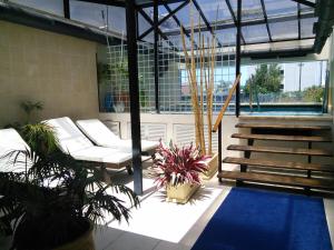 a patio with white furniture and plants in a building at Long Beach, Parada 3 in Punta del Este +16 photos