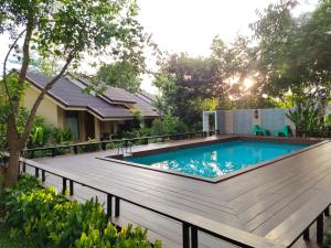 a swimming pool on a wooden deck next to a house at Mamaungpaa Hill resort in Ta Khli