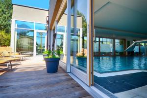a house with a pool and a potted plant on a porch at Aktiv- und Wellnesshotel Gutjahr in Abtenau