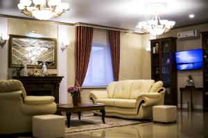 a living room with two chairs and a tv at Premier Hotel in Smolensk