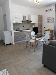 cocina y sala de estar con mesa y sillas en Appartamento in centro paese, en Monterosi