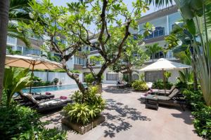峴港的住宿－Grandvrio City Danang By Route Inn Group，庭院设有游泳池、椅子和一棵树