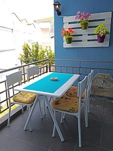 een tafel en stoelen op het balkon bij Iro Apartment in Néa Péramos
