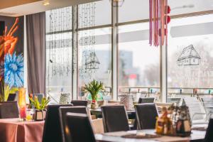a restaurant with tables and chairs and a large window at Hotel Forum in Rzeszów