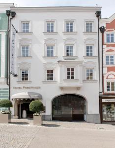 a large white building with a store front at Hotel Forstinger - Boutique Hotel Schärding in Schärding