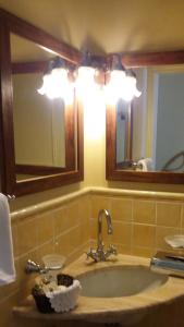 a bathroom with a sink, mirror, and bathtub at Hotel Gallo Nero in SantʼAndrea