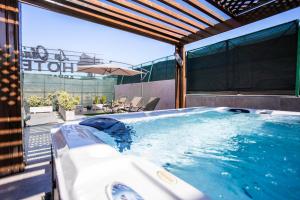uma grande banheira de hidromassagem num pátio com um guarda-sol em Aparthotel Les Oliviers Suites & Spa em Fez