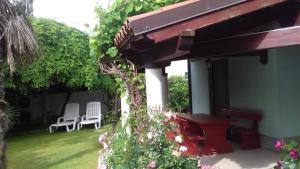 a patio with two chairs and a table and flowers at Villa Verde Apartments and Rooms in Premantura