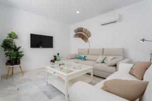 ein weißes Wohnzimmer mit einem Sofa und einem Tisch in der Unterkunft Apartamento La Pepa de ORO by Cadiz4Rentals in Cádiz