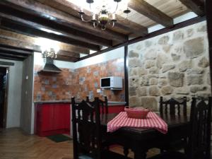 una sala da pranzo con tavolo e parete in pietra di La casa de los abuelos lugar para disfrutar a Amusco