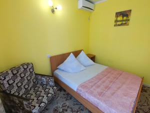 ゲレンジークにあるDomik u moryaの小さなベッドルーム(ベッド1台、椅子付)