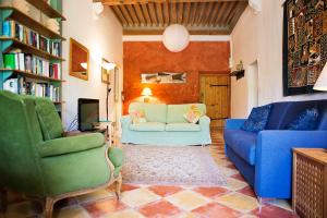 a living room with a couch and chairs and a tv at The Balcony Gîte - Riverside Lagrasse in Lagrasse