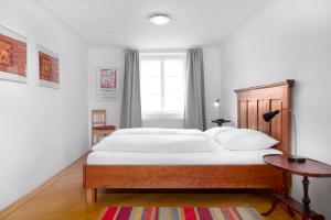sypialnia z dużym białym łóżkiem i oknem w obiekcie Apartments Golden Roof by Penz w mieście Innsbruck