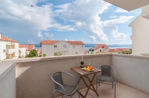 einen Tisch und zwei Stühle auf einem Balkon mit Aussicht in der Unterkunft Villa Juraj in Bol