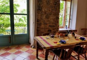 a dining room with a table and a window at The Balcony Gîte - Riverside Lagrasse in Lagrasse