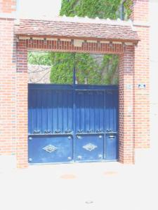uma porta de garagem azul num edifício de tijolos em Les Bains Bed & Breakfast em Cheny