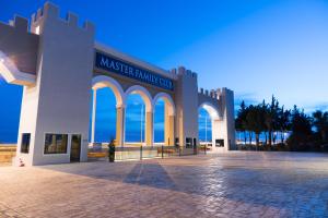 a large building with large arches in front of the ocean at Master Family Club in Manavgat