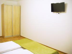 ヨシュカル・オラにあるMira Apartmentの壁にテレビとベッドが備わる客室です。