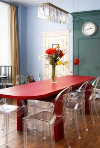 a red dining room table with chairs and a vase of flowers at Guest House Yum Yum in Moscow