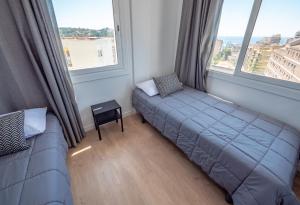 a bedroom with a bed and a couch and windows at Apartamentos AR Melrose Place in Lloret de Mar +55 photos
