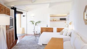 a white bedroom with a bed and a table at LUX-Porto Cervo Center Sea View Apartment in Porto Cervo