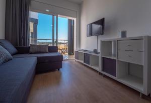 a living room with a couch and a tv at Apartamentos AR Melrose Place in Lloret de Mar