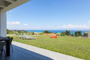 a patio with chairs and a view of the ocean at Villa Rossa in Hanioti