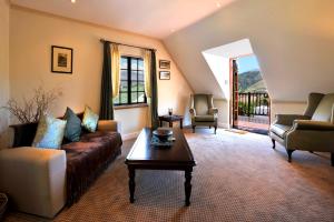 a living room with a couch and two chairs and a table at Gable Manor in Franschhoek