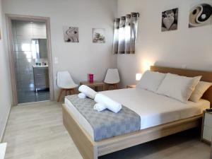 a bedroom with a bed with white pillows on it at Neva Apartments by the Beach in Makry Gialos