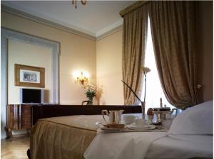 a hotel room with a bed with a table with teaitures at Villa Fenaroli Palace Hotel in Rezzato