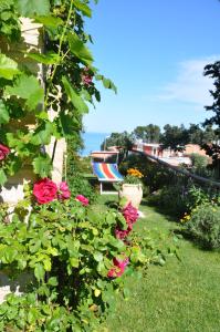 a garden with a bench and flowers and the ocean at Bed and Breakfast Latteletto in Tortoreto Lido +2 photos