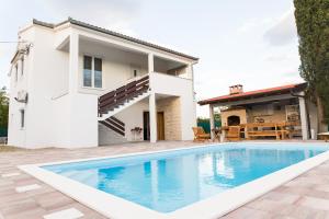 a villa with a swimming pool in front of a house at Villa Nava in Benkovac