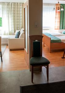 ein Wohnzimmer mit einem Stuhl und ein Schlafzimmer in der Unterkunft Apartment am Bahnhof in Salzburg