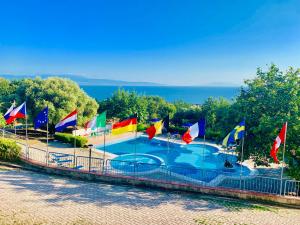 un gruppo di bandiere su una recinzione intorno alla piscina di NaturaMare Apartments - Piscina Idromassaggio con Vista Mare Aperta fino alle ore 22-00 a Capo Vaticano