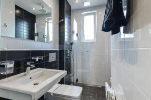 ein Badezimmer mit einem Waschbecken, einem WC und einem Spiegel in der Unterkunft Sofia Dream Apartments - Rock'n'Roll One Bedroom in Sofia