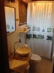 a bathroom with a sink and a toilet at Paradise Beach House in Imbassai