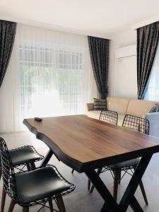 a dining room table with chairs and a couch at AdaHan Family Rooms Gocek in Göcek
