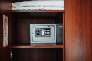 a microwave in a wooden cabinet with a bed in it at Hotel Diana in Arzamas