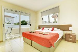 a bedroom with a bed and a balcony at Nissi Martha Apartment in Ayia Napa +32 photos