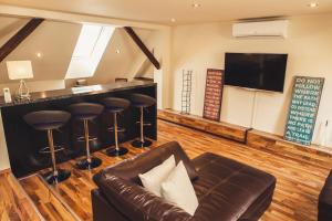 a living room with a leather couch and a bar at SKOL apartment in Celje