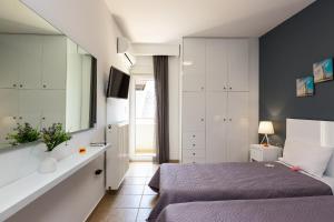 une chambre avec un lit et une grande fenêtre dans l'établissement White Coral, à Réthymnon