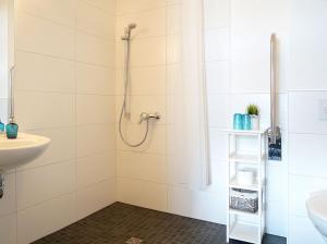 ein Bad mit einer Dusche und einem Waschbecken in der Unterkunft Boootshaus - Am Spreeufer in Beeskow