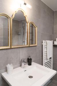 łazienka z białą umywalką i lustrem w obiekcie Apartments Golden Roof by Penz w mieście Innsbruck +33 zdjęcia