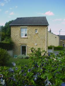 a brick house with a black roof at La Petite Maison in Clavy-Warby